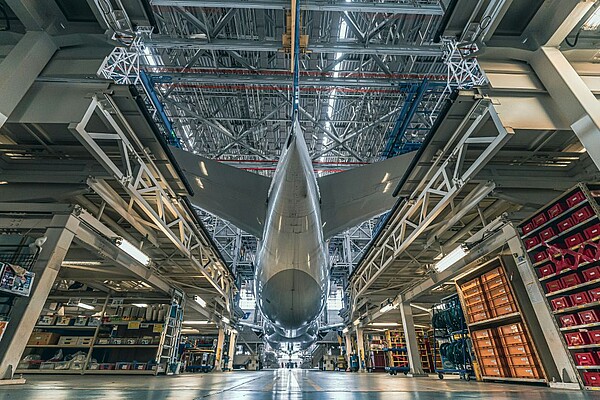 An aeroplane in a warehouse, captured from beneath.