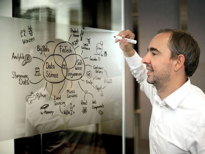 A man explains technical concepts on a whiteboard